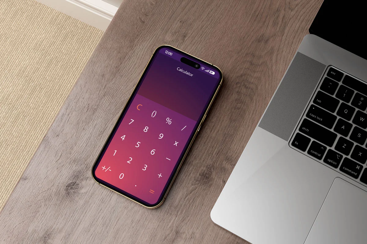 A mobile phone on a desktop, displaying a calculator on its screen